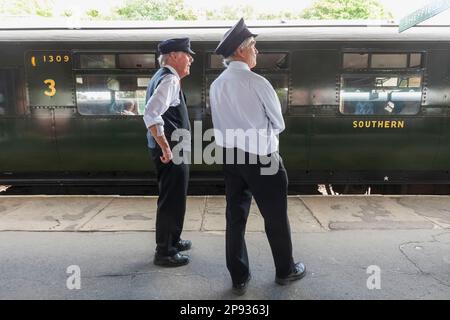 Inghilterra, Sussex, Bluebell Railway, Horsted Keynes Station, Guardie sulla piattaforma della stazione Foto Stock