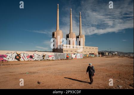 L'uomo cammina nei camini dell'ex centrale termale di Sant Adria del Besos, nota come Tres Xemeneies o Tres Chimeneas, e chiusa dal 2011. Foto Stock