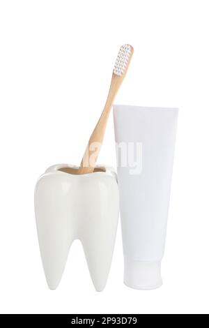 Supporto a forma di dente con spazzola vicino al tubo di dentifricio su fondo bianco Foto Stock