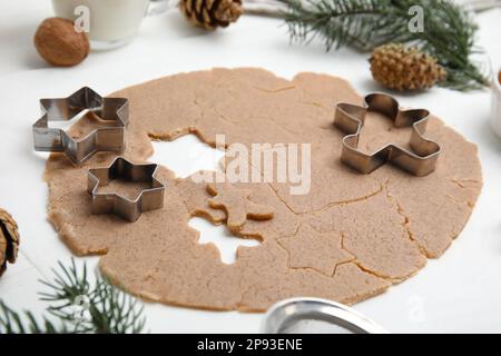 Biscotti di Natale fatti in casa. Frese per pasta cruda e biscotti su un tavolo bianco Foto Stock