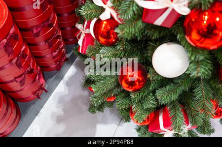 Albero di Natale decorato, scatole regalo rosse, decorazioni di Natale, Garland lucido sui rami verdi, sfondo di Natale sfocato con Copy Space Foto Stock