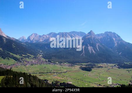 Vista dal Tuftlalm (1496m m) a Ehrwald e alla catena montuosa Mieminger, con le prominenti Sonnenspitze (2417m m), Lermoos, Zugspitzarena, Tirolo, Austria Foto Stock