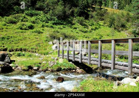 Ponte in legno sul Fotscher Bach sulla strada per il Potsdamer Hütte nella Fotschertal Sellrain, Innsbruck, Tirolo, Austria Foto Stock