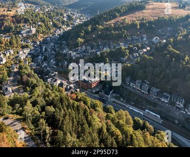 Germania, Turingia, Lauscha, piccola città, si estende su diverse valli strette, stazione ferroviaria, treni regionali, montagne, foresta, luce mattutina, panoramica, vista obliqua, vista aerea Foto Stock