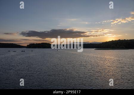 Germania, Brandeburgo, Zootzensee, Distretto dei Laghi di Meclemburgo, Parco dei Laghi di Müritz, canoista al tramonto Foto Stock