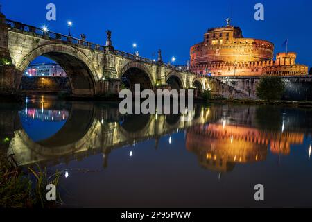 Il Ponte degli Angeli/Pons Aelius/Ponte Sant'Angelo si affaccia sul Castel Sant'Angelo cortile d'onore o cortile dell'Angelo di notte, illuminato. Roma, Italia Foto Stock