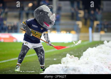 Leeds Rhinos mascotte Ronnie Rhino libera la neve dal lato del campo prima della partita Betfred Super League Round 4 Leeds Rhinos vs Wakefield Trinity allo Headingley Stadium, Leeds, Regno Unito, 10th marzo 2023 (Foto di Steve Flynn/News Images) Foto Stock