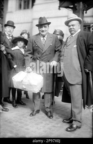 1918 ca , New York , USA : il cantante italiano Enrico CARUSO ( Napoli 1873 - 1921 ) alla stazione centrale sorridendo con altri colleghi e ironizzando con una scatola piena di cibo per il viaggio inviato dai suoi tifosi . - MUSICA CLASSICA - CLASSICA - MUSICA - ritratto - cappello - cravatta - cravatta - TENORE - OPERA LIRICA - TEATRO - TEATRO - tournee - sorriso - sorriso ---- Archivio GBB Foto Stock