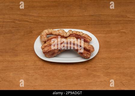 Un torrezno è una striscia di pancetta, sempre con la pelle sopra, fritta o saltata in una padella o tostata sulla griglia. i torreznos sono croccanti e dorati sul Foto Stock