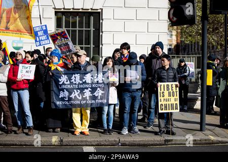 Londra, Regno Unito. 10th Mar, 2023. I manifestanti hanno cartelli e una bandiera a sostegno di Hong Kong durante il rally di fronte all'Ambasciata della Cina a Londra durante la Giornata Nazionale di rivolta Tibetana. Centinaia di tibetani residenti a Londra hanno marciato da Downing Street all'ambasciata cinese a Londra in occasione del 64th° anniversario della Giornata nazionale tibetana di rivolta. La marcia commemora decine di migliaia di tibetani che si sono alzati contro l'invasione e l'occupazione illegale della loro patria da parte della Cina il 10th marzo 1959. Credit: SOPA Images Limited/Alamy Live News Foto Stock