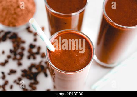 Tre frullati di caffè-moka con cannucce di carta: Vista dall'alto di un gruppo di frullati per la colazione preparati con caffè e cacao in polvere Foto Stock