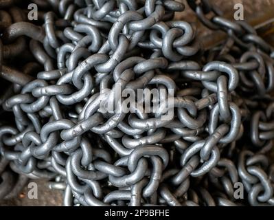 Catene rotonde in acciaio per attrezzature e sistemi di trasporto e sollevamento, primo piano e focalizzazione selettiva Foto Stock