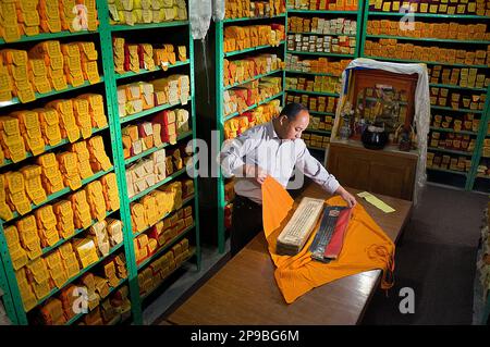 Sonam Topgyal riesamina lo stato di conservazione del Kanjur, parole di buddha, nella Biblioteca di opere e archivi tibetani, Dharamsala, Himachal Prade Foto Stock