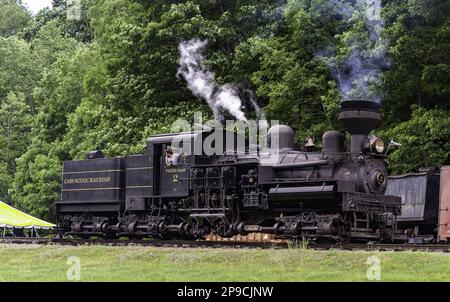 Cass, West Virginia, 18 giugno 2022 - un motore a vapore Antique Shay, che viaggia da solo, soffiando fumo e vapore su un percorso ferroviario, in un giorno d'estate Foto Stock