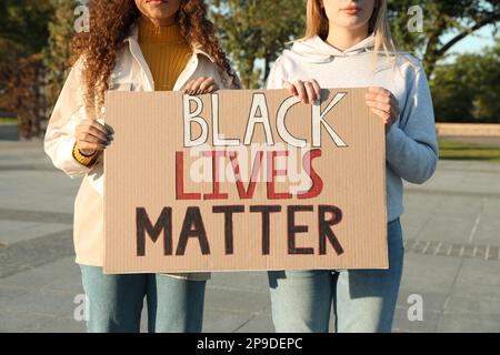 Le donne che tengono il segno con la frase Black Lives contano all'aperto, primo piano. Concetto di razzismo Foto Stock