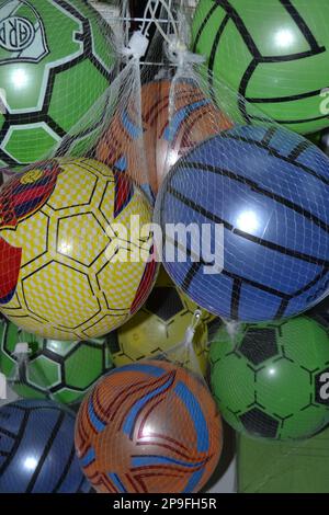 Palline in plastica colorate appese al rack del display Foto Stock