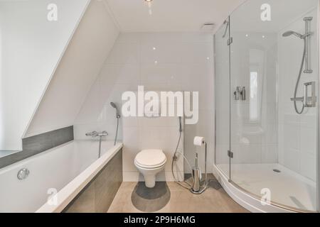 un bagno con wc, doccia e vasca nell'angolo accanto è un attico stile loft Foto Stock