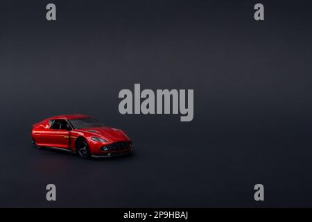 Una foto di un'auto giocattolo rossa su sfondo nero isolato, dopo alcune modifiche. Foto Stock