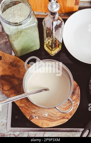 Preparazione di frittelle sottili in padella in cucina, con pasta da cucina per crepes e frittelle. Foto Stock