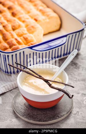 Buchteln, panini dolci a base di lievito con latte e burro, serviti con salsa alla vaniglia. Piatto tradizionale senza carne in Europa Foto Stock