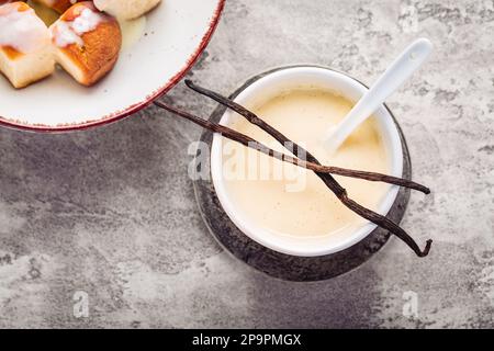 Buchteln, panini dolci a base di lievito con latte e burro, serviti con salsa alla vaniglia. Piatto tradizionale senza carne in Europa Foto Stock