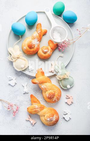 Cottura di Pasqua - conigli di pasta di lievito a forma di coniglietto pasquale e uova colorate Foto Stock