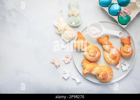 Cottura di Pasqua - conigli di pasta di lievito a forma di coniglietto pasquale e uova colorate Foto Stock