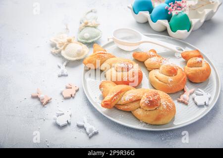 Cottura di Pasqua - conigli di pasta di lievito a forma di coniglietto pasquale e uova colorate Foto Stock