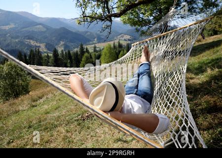 Giovane uomo che riposa in amaca all'aperto nelle giornate di sole Foto Stock