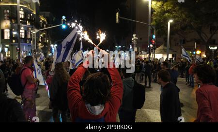 TEL AVIV, ISRAELE - 9 MARZO: I manifestanti anti dell'anti-governo detengono bandiere israeliane mentre bloccano Allenby Street durante una manifestazione di massa contro il piano del sistema giudiziario del governo di estrema destra di Israele che mira a indebolire la Corte Suprema del paese il 9 marzo 2023 a Tel Aviv, Israele. Foto Stock