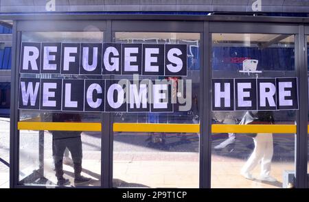 Cartello "i rifugiati sono i benvenuti", volato su un rifugio per autobus a Manchester, Regno Unito. Ciò è in reazione al controverso piano del governo britannico volto a bloccare l'ingresso di migranti non documentati nel paese con piccole imbarcazioni. Foto Stock