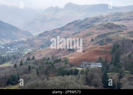 Splendida vista panoramica dell'alba invernale da Loughrigg cadde attraverso la campagna verso Langdale Pikes e Pike o'Blisco nel Lake District Foto Stock