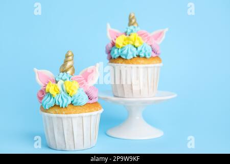 Tortini dolci e carini di unicorno su sfondo azzurro Foto Stock