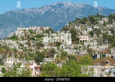 Vista sulle case in rovina di Kayakoy (Levissi) abbandonato villaggio vicino Fethiye nella provincia di Mugla in Turchia. Levisi fu disertata dalla sua maggior parte greca Foto Stock