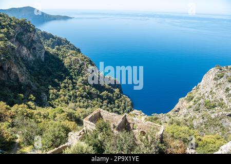 Costa mediterranea vicino al villaggio di Kayakoy nella provincia di Mugla in Turchia, con le rovine del monastero di Afkule. Il monastero greco fu abbandonato nel 192 Foto Stock