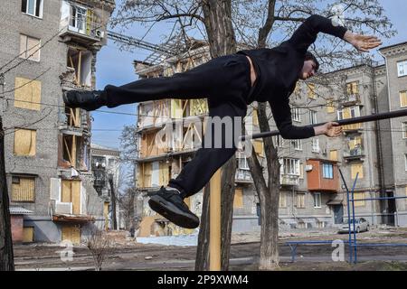 Zaporizhzhzhia, Ucraina. 25th Feb, 2023. Un adolescente ha visto praticare sul bar orizzontale vicino all'edificio dell'appartamento danneggiato da una conchiglie russa. I bambini e le famiglie ucraine hanno subito un anno di violenza crescente, traumi, distruzione e sfollamenti. I bambini continuano ad essere uccisi, feriti e profondamente traumatizzati dalla violenza che ha innescato sfollamenti su una scala e velocità non viste dalla seconda guerra mondiale (Foto di Andriy Andriyenko/SOPA Images/Sipa USA) Credit: Sipa USA/Alamy Live News Foto Stock