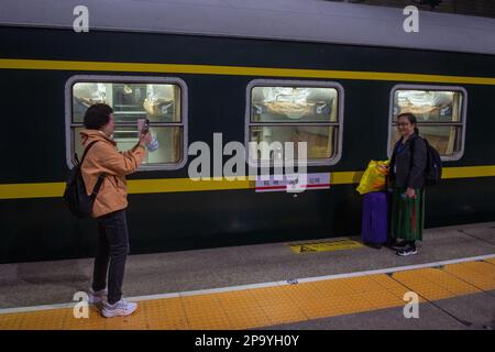 (230311) -- HANGZHOU, 11 marzo 2023 (Xinhua) -- i passeggeri scattano foto di fronte al treno n. Y71 presso la stazione ferroviaria di Hangzhou, provincia di Zhejiang nella Cina orientale, 10 marzo 2023. La notte del 10 marzo, treno n.. Y71, un treno noleggiato per il turismo ferroviario trans-provinciale, partì dalla stazione ferroviaria di Hangzhou, trasportando oltre 420 passeggeri all'altopiano di Yunnan-Guizhou. Come la primavera arriva, China Railway Shanghai Bureau Group Co., Ltd. Ha attivamente formulato piani di turismo ferroviario di alta qualità e ha iniziato il funzionamento di treni noleggiati per destinazioni popolari, a Cred Foto Stock