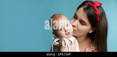 Bella madre baciare il suo bambino carino su sfondo azzurro, spazio per il testo. Design del banner Foto Stock