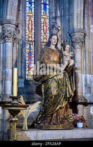 Statua o scultura della Vergine Maria con Gesù Bambino. L'antico pezzo d'arte sta decorando il caratteristico edificio cattolico. Foto Stock