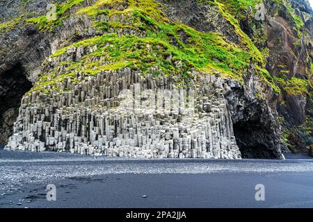 Vista di Reynisdrangar, il mare basalto stack sul monte Reynisfjall e la Reynisfjara spiaggia di sabbia nera vicino Vik in Islanda nella stagione estiva Foto Stock