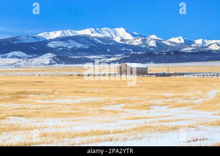fienile e campi di fattoria sotto il monte haggin in inverno nei pressi di anaconda, montana Foto Stock