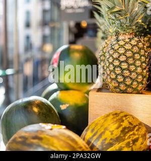 Ananas e meloni esposti per la vendita in un negozio di frutta a Madrid, Mercado de San Miguel. Foto Stock