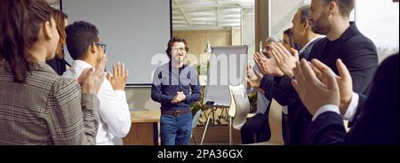 Gruppo di persone sono saluto uomo allenatore in ufficio moderno clapping mani, aducation concetto adulto. Foto Stock