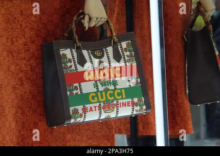 New York, NY - 28 ottobre 2021: La musica è mia, Gucci sedili in pelle marrone reclinata e borsetta materiale in mostra alla 5th Avenue Gucci di New York City Foto Stock
