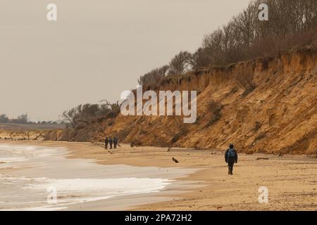 Camminatori a piedi vicino alle scogliere di sabbia erodente sulla spiaggia di Easton Wood tra Southwold e Covehithe sulla costa di Suffolk, Regno Unito Foto Stock