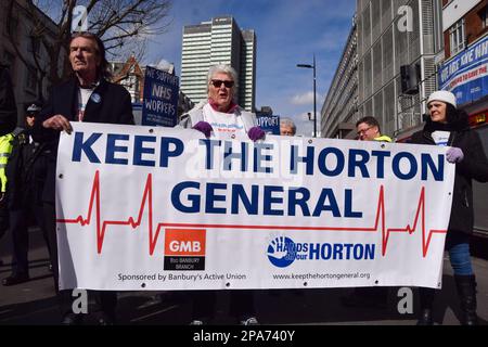 Londra, Regno Unito. 11th marzo 2023. I manifestanti di Tottenham Court Road hanno una bandiera a sostegno dell'Horton General Hospital. Migliaia di persone hanno marciato attraverso il centro di Londra a sostegno dei lavoratori dell'NHS e dell'NHS e per protestare contro la privatizzazione dell'NHS. Credit: Vuk Valcic/Alamy Live News Foto Stock