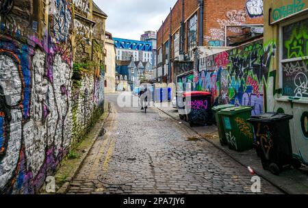 I graffiti hanno coperto le pareti di uno stretto vicolo nella zona di Stokes Croft vicino al centro della città di Bristol, Regno Unito Foto Stock