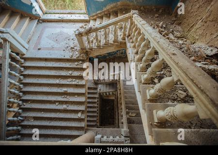 Vista dall'alto di una vecchia scala decorata in stile vintage in un palazzo abbandonato. Foto Stock