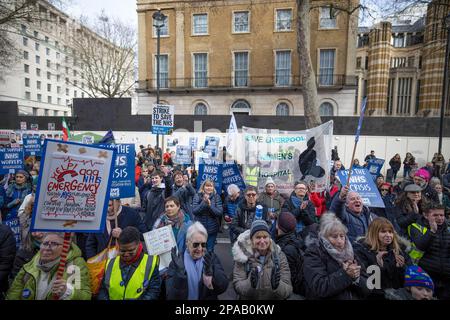 Londra, Regno Unito. 11th Mar, 2023. I lavoratori del NHS, compresi medici e infermieri, e il loro sostenitore, hanno dei cartelli durante la manifestazione. Il gruppo della campagna SOS NHS e altri sindacati hanno organizzato una marcia dall'University College London Hospital a Downing Street per chiedere finanziamenti di emergenza al National Health Service (NHS) da parte del governo britannico per sostenere i servizi e il personale e non privatizzare il settore sanitario prima della primavera del Cancelliere Bilancio in data 15th marzo 2023. Credit: SOPA Images Limited/Alamy Live News Foto Stock