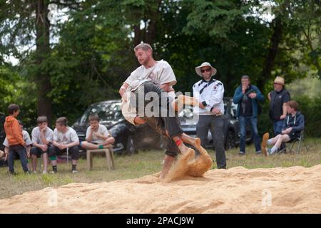 Pleyber-Christ, Francia - 29 2022 maggio: Due lottatori bretoni (gouren) durante una partita che si svolge sulla segatura. Foto Stock